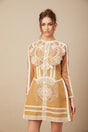 A short white lace dress with a peplum waist and cutout details featuring a fitted bodice and flared skirt