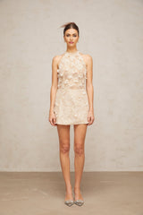 A short white lace mini dress with neutral colored flower appliques adorning the fabric