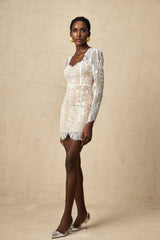 A short white lace mini dress with scalloped hem and delicate floral patterns