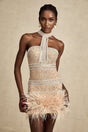 A short white mini dress adorned with crystal embellishments and featuring delicate feather trim along the hemline and neckline