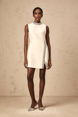 A short white mini dress adorned with crystal embellishments featuring a feminine silhouette and elegant design