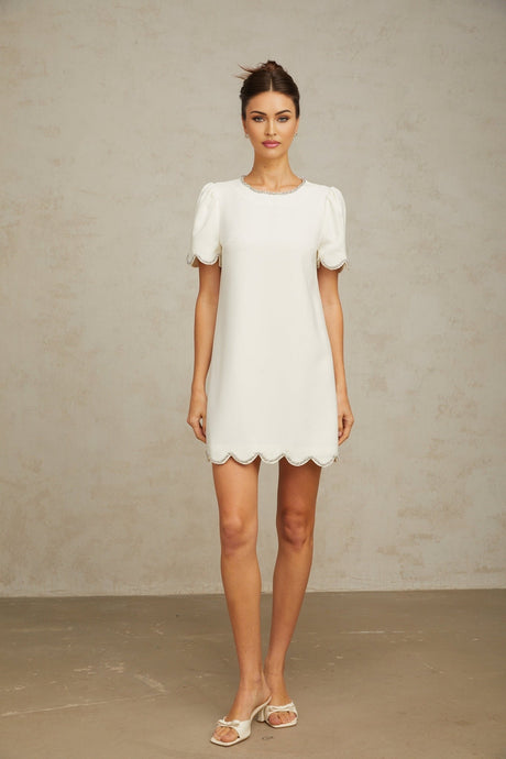 A short white mini dress adorned with crystal embellishments featuring a fitted silhouette and delicate detailing