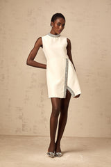 A short white mini dress adorned with crystal embellishments featuring a sleek and feminine design