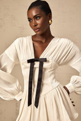 A short white mini dress with a bowknot detail and glitter accents named Lina