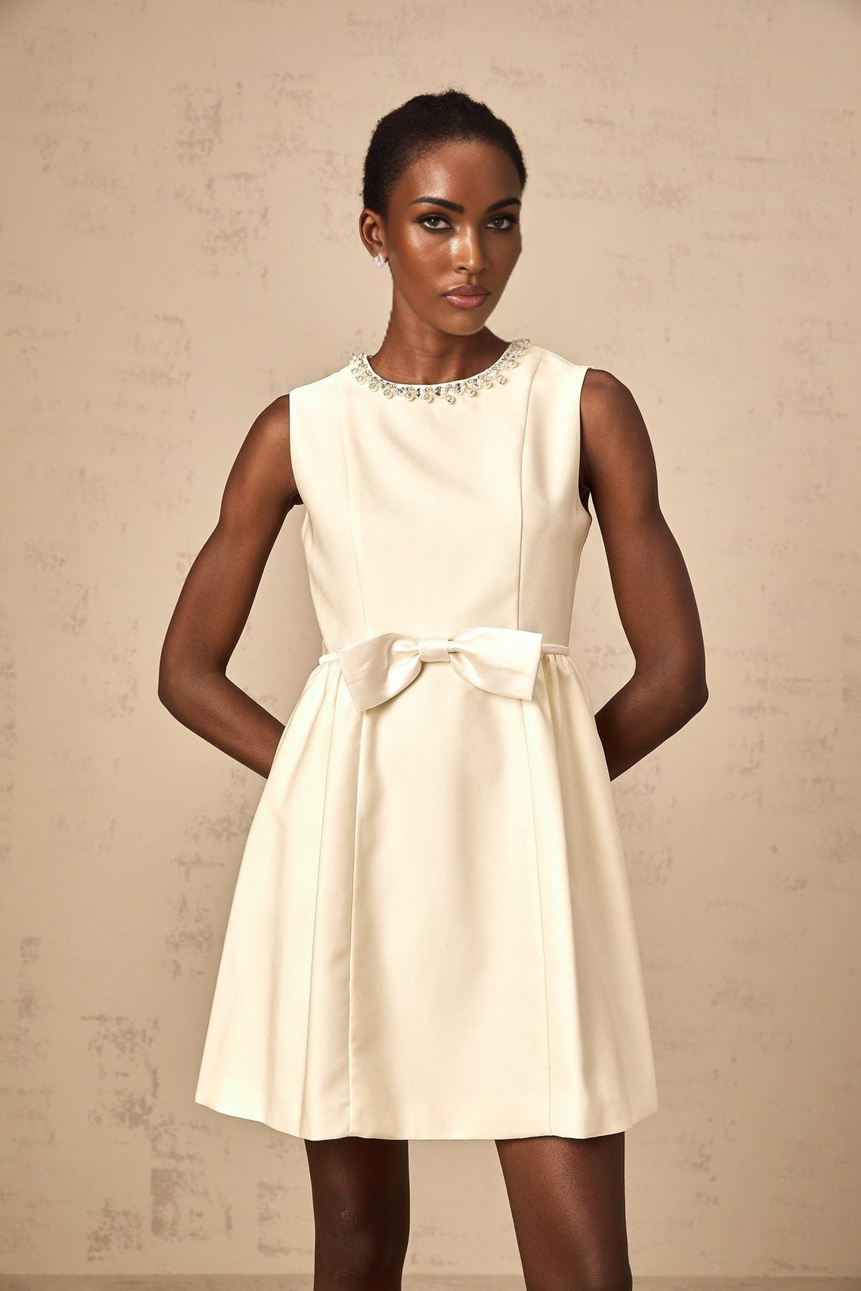 A short white mini dress with a bowknot embellishment named Isabelle