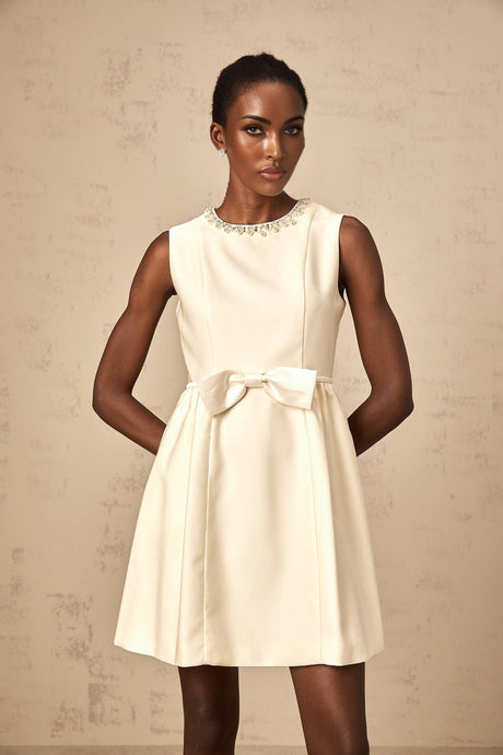 A short white mini dress with a bowknot embellishment named Isabelle