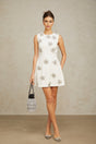 A short white mini dress with a delicate floral pattern adorned with crystal embellishments featuring a feminine silhouette and Coralie design