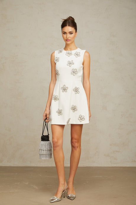 A short white mini dress with a floral pattern made of crystal embellishments featuring a delicate flower motif design throughout
