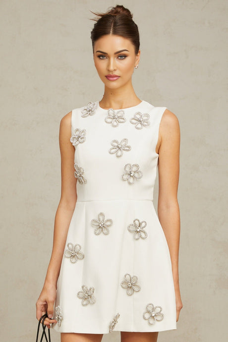 A short white mini dress with a floral pattern made of crystals covering the fabric named Coralie