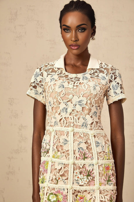 A short white mini dress with colorful floral embroidery details featuring a feminine silhouette and delicate straps