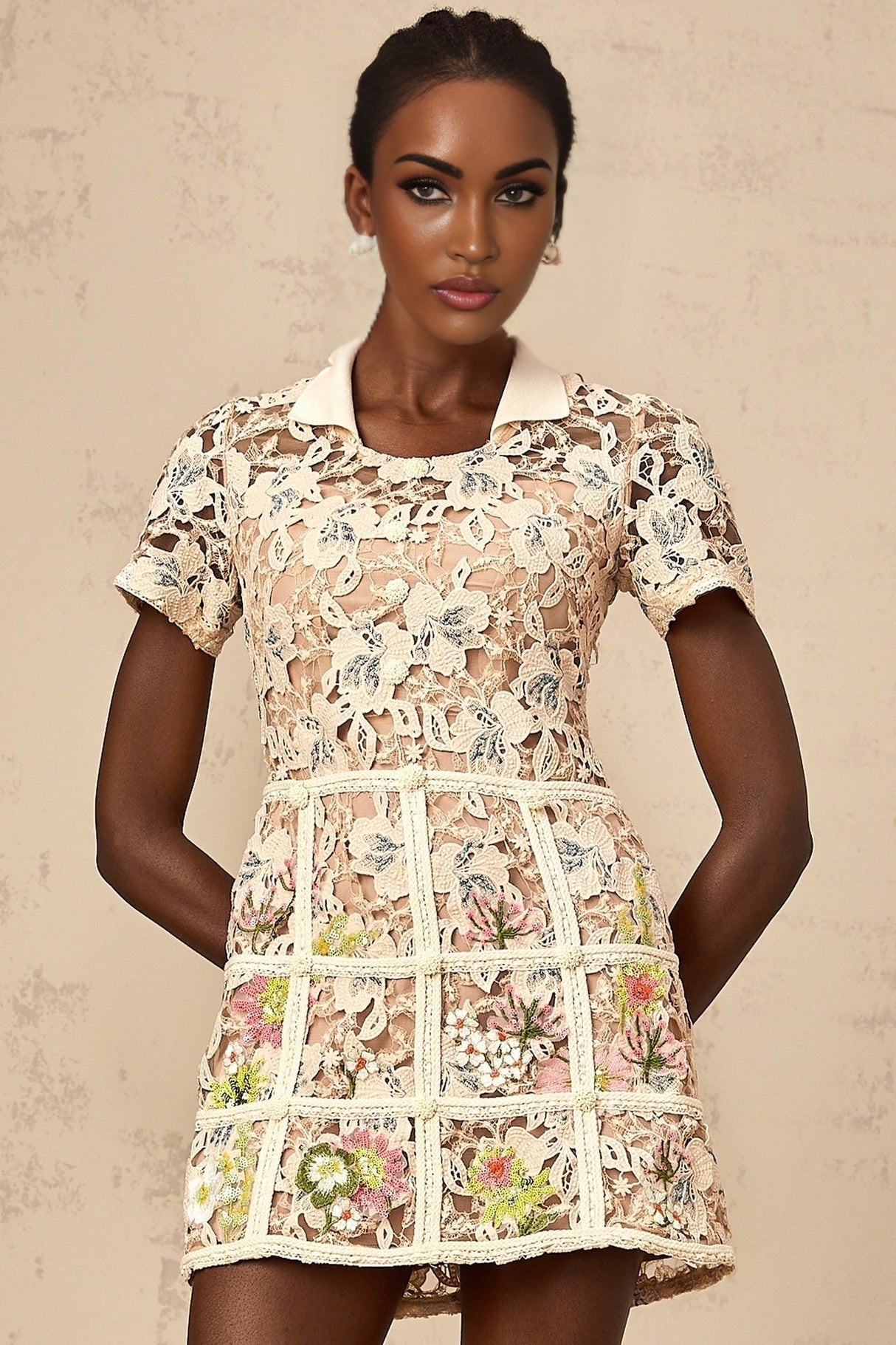 A short white mini dress with colorful floral embroidery pattern featuring a fitted bodice and flared skirt