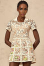 A short white mini dress with colorful floral embroidery pattern featuring a fitted bodice and flared skirt