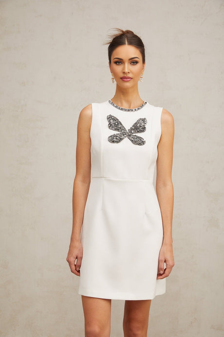 A short white mini dress with crystal butterfly embellishments on the fabric
