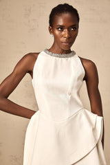 A short white mini dress with crystal embellishments and layered design worn by a model against a plain background