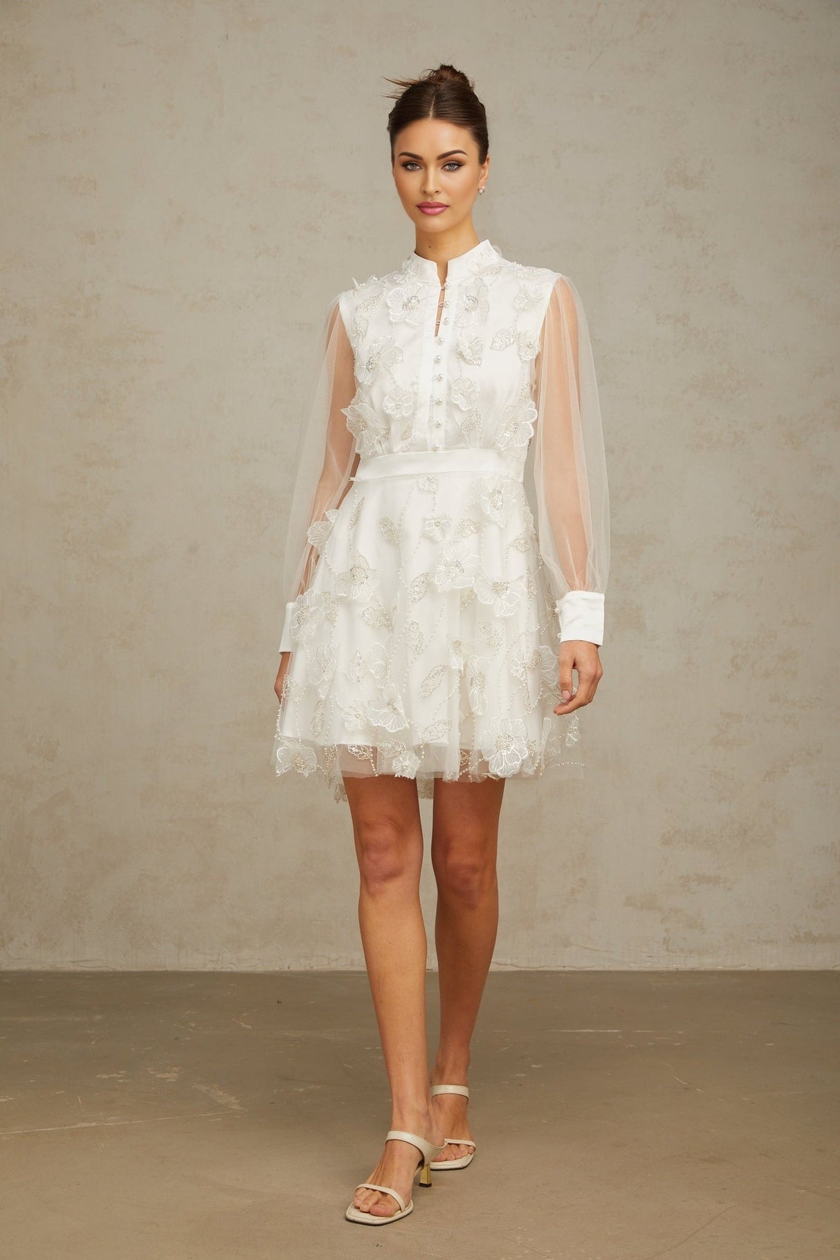 A short white mini dress with delicate 3D floral petal details made of tulle fabric named Camille