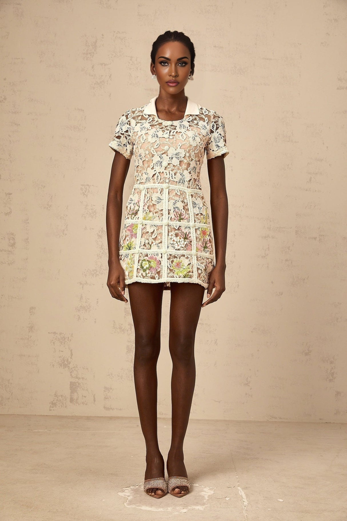 A short white mini dress with delicate floral embroidery featuring a feminine and romantic design