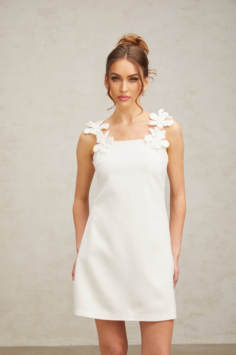 A short white mini dress with faux flower embellishments decorating the fabric