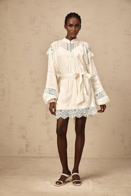 A short white mini dress with floral lace trim details featuring a delicate and feminine design