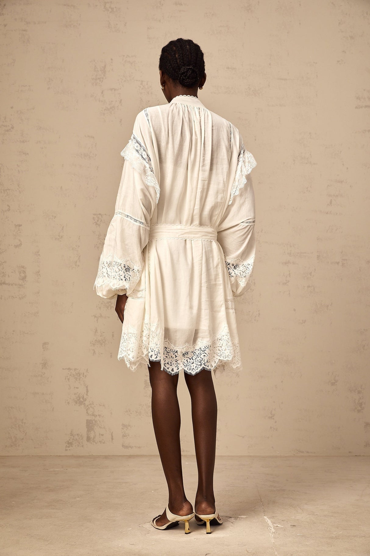 A short white mini dress with floral lace trim details featuring a delicate feminine design