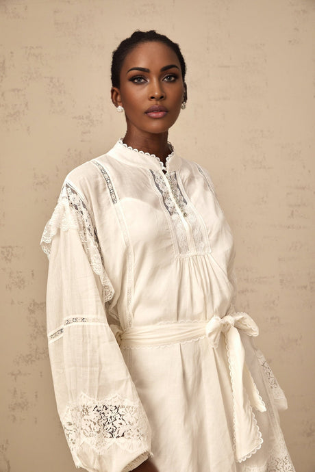 A short white mini dress with floral lace trim details featuring a feminine and delicate design