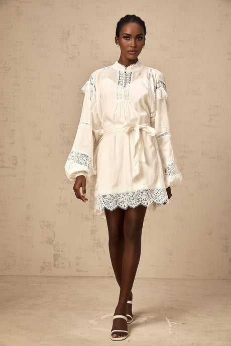 A short white mini dress with floral lace trim details