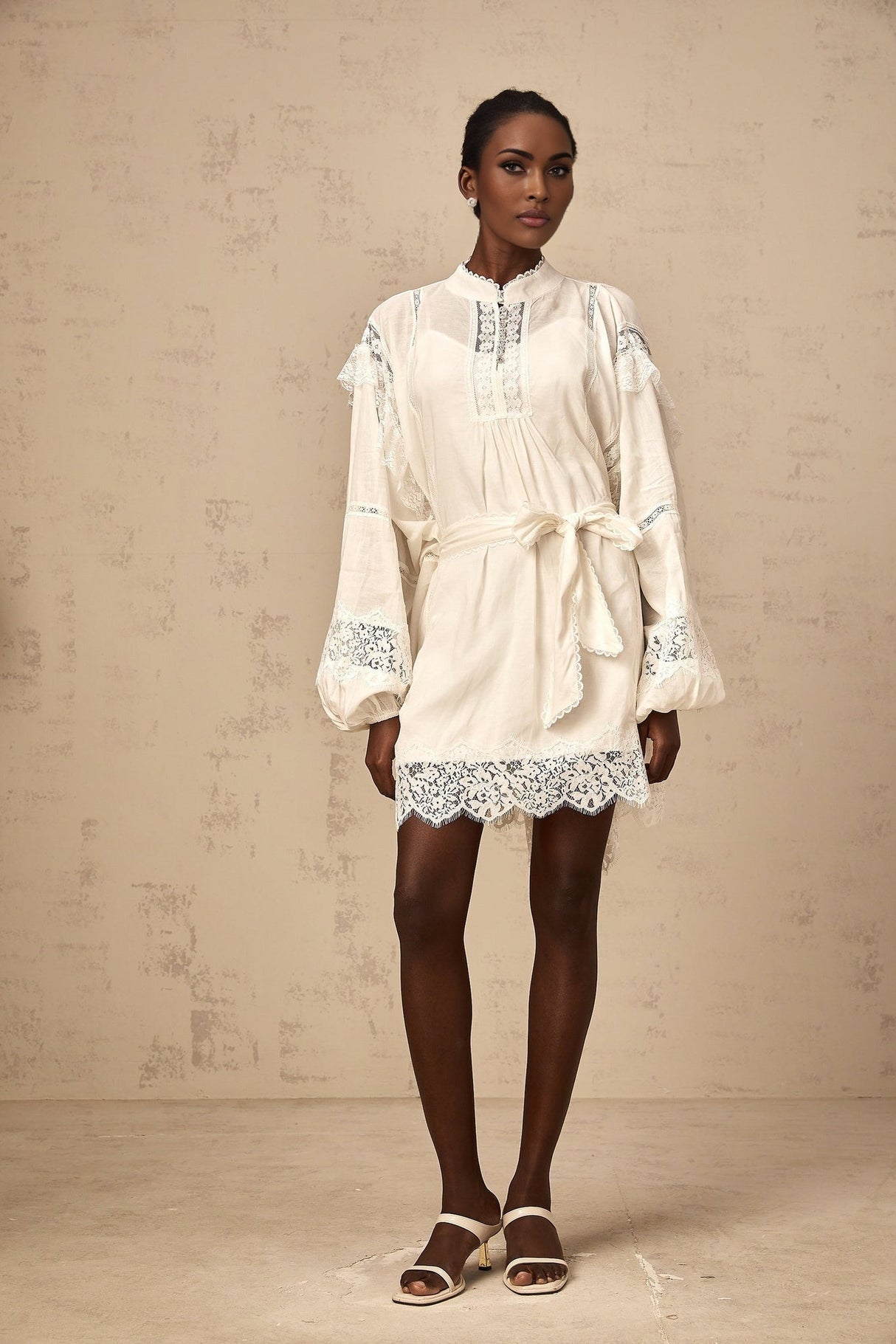 A short white mini dress with floral lace trim details