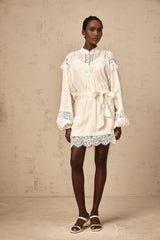 A short white mini dress with floral lace trim details