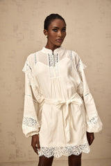 A short white mini dress with floral lace trim details