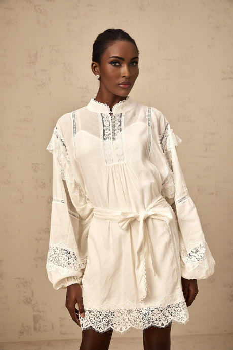 A short white mini dress with floral lace trim details