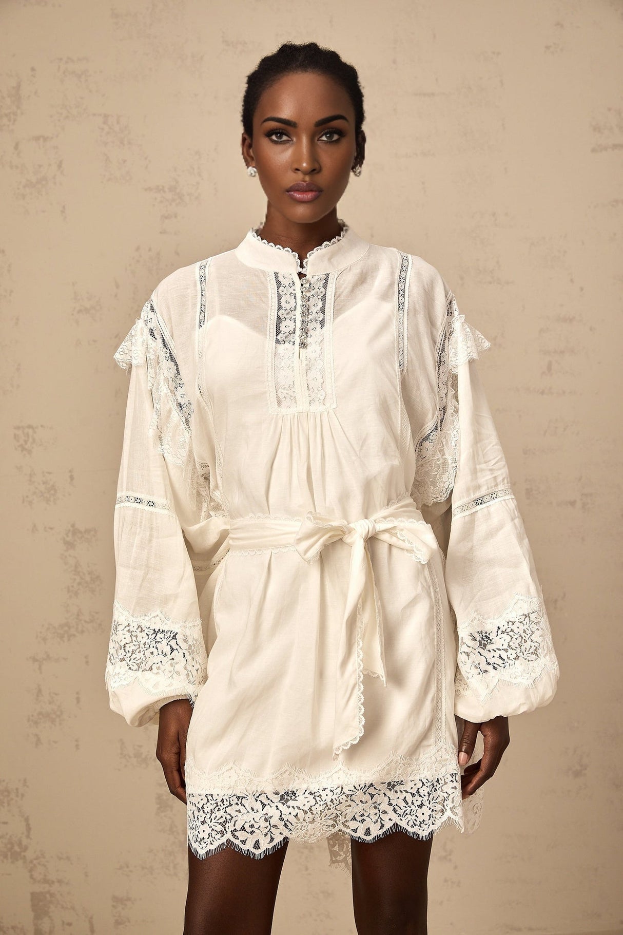 A short white mini dress with floral lace trim details