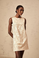 A short white mini dress with intricate embroidery and beaded embellishments adorning the fabric