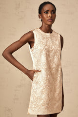 A short white mini dress with intricate embroidery and beaded embellishments adorning the fabric