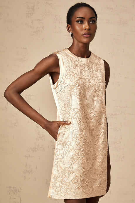 A short white mini dress with intricate embroidery and beaded embellishments adorning the fabric