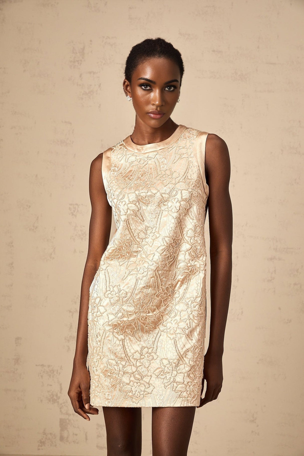 A short white mini dress with intricate embroidery and beaded embellishments featuring delicate patterns and a feminine silhouette