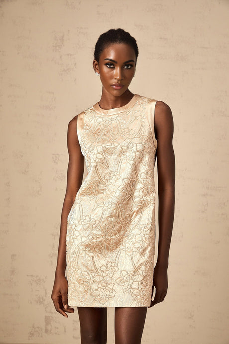A short white mini dress with intricate embroidery and beaded embellishments featuring delicate patterns and a feminine silhouette