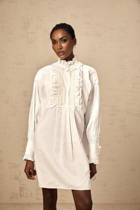 A short white mini dress with lace trim and ruffles featuring a shirtstyle design and buttonup front