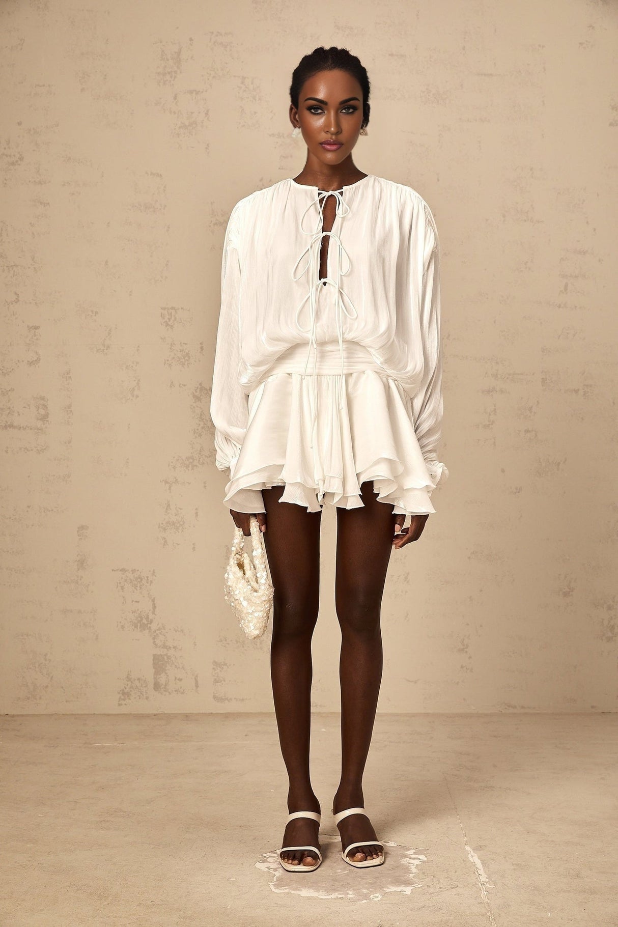 A short white mini dress with pleated fabric and glitter effect named Mahault featuring a sleeveless design and flared skirt