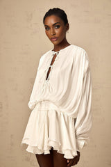 A short white mini dress with pleated fabric and glitter effect named Mahault featuring a sleeveless design and flared skirt