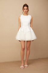 A short white mini dress with puff sleeves and tulle panelling featuring a flared skirt and fitted bodice