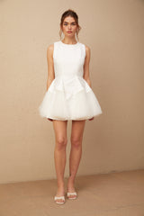 A short white mini dress with puff sleeves and tulle panels featuring a fitted bodice and flared skirt