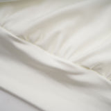 A short white mini dress with ruched detailing and faux flower embellishments