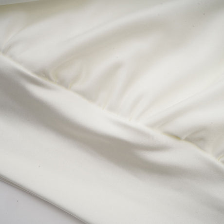 A short white mini dress with ruched detailing and faux flower embellishments