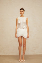 A short white mini dress with ruched fabric and floral applique details
