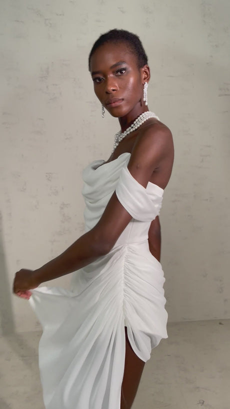 A short white mini dress with ruched fabric and ribbon design details featuring a fitted silhouette and named Gitta