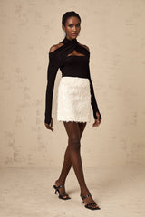 A short white mini skirt adorned with shimmering sequins reflecting light