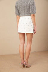 A short white mini skirt with a crystalembellished bowknot detail on the front