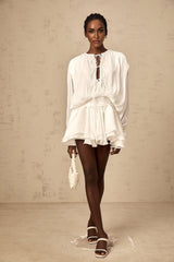 A short white pleated mini dress with a glittery shimmering effect named Mahault
