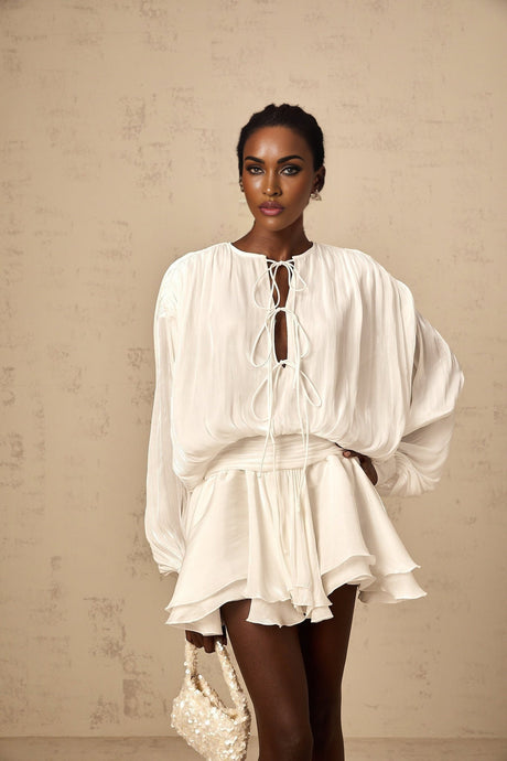 A short white pleated mini dress with a glittery shimmering effect named Mahault