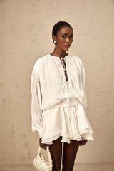 A short white pleated mini dress with a glittery shimmering effect named Mahault