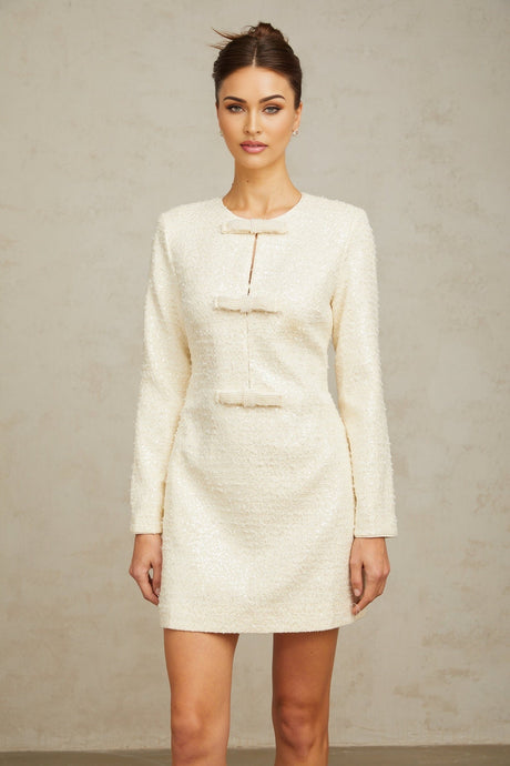 A short white tweed mini dress adorned with sparkling sequins featuring a feminine and elegant design
